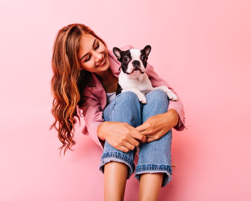Smiling woman with her dog on her lap